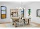 Dining room boasts natural light, wood table, chandelier, art, and a neutral color palette at 1126 S Garfield St, Denver, CO 80210