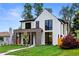 Beautiful home featuring a mix of white siding, brickwork, expansive windows, and a well-manicured lawn at 1126 S Garfield St, Denver, CO 80210