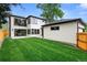 Rear exterior featuring a modern home with black trim, large windows, well-manicured lawn and a detached garage at 1126 S Garfield St, Denver, CO 80210