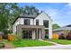 Stylish two-story home with white siding, brick details, dark-framed windows, and green grass at 1126 S Garfield St, Denver, CO 80210