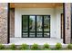 Inviting front porch with brick columns, sleek black window frames, and a modern wood door at 1126 S Garfield St, Denver, CO 80210