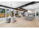 Open-concept living space with dining area, modern kitchen, exposed beams, and staircase at 1126 S Garfield St, Denver, CO 80210
