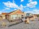 Well-maintained home exterior featuring stone accents, gravel landscaping, metal garden planters, and a cozy patio area at 1297 Black Haw St, Elizabeth, CO 80107