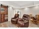 Finished basement featuring a rustic sliding barn door, plush leather recliners, and wood-look flooring at 1297 Black Haw St, Elizabeth, CO 80107
