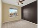 Bright and airy bedroom with a large window providing natural light, plush carpet, and modern ceiling fan at 1297 Black Haw St, Elizabeth, CO 80107