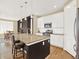 Open kitchen with a granite island and bar seating, stainless steel appliances, and wood floors at 1297 Black Haw St, Elizabeth, CO 80107