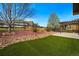 Lush backyard with green grass, a wooden fence, and a wooden pergola at 15851 Josephine Cir, Brighton, CO 80602