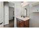 Bathroom with wood vanity, sink, and a large mirror, leading to other rooms at 15851 Josephine Cir, Brighton, CO 80602