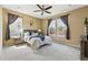 Bright bedroom with large windows, ceiling fan, and neutral carpet flooring at 15851 Josephine Cir, Brighton, CO 80602
