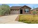 Charming single-story home featuring a stone facade, attached garage, and well-maintained lawn at 15851 Josephine Cir, Brighton, CO 80602