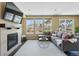 Inviting living room with a fireplace, hardwood floors, and ample natural light from the bright, sunlit windows at 15851 Josephine Cir, Brighton, CO 80602