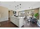Open-concept living area showcasing a kitchen island, fireplace, dining table, and living room area at 15851 Josephine Cir, Brighton, CO 80602