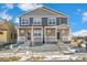 Traditional-style home featuring stone accents, gray siding, and a charming front porch with white railing at 18714 E 99Th Ave, Commerce City, CO 80022
