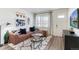 Open-concept living room features modern decor, a comfortable sofa, and a large window with natural light at 18714 E 99Th Ave, Commerce City, CO 80022