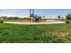 Community playground featuring play structures with green lawn, and views of nearby lawns and a red gazebo at 18714 E 99Th Ave, Commerce City, CO 80022