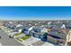 A wide shot captures a neighborhood street with modern homes and attached two-car garages at 18714 E 99Th Ave, Commerce City, CO 80022