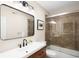 Bright bathroom with a modern vanity, large mirror, and tiled shower with glass door at 2400 S Columbine St, Denver, CO 80210