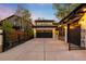 Spacious driveway leading to garages with stylish lighting, complemented by an ornamental iron gate and landscaping at 2400 S Columbine St, Denver, CO 80210