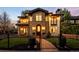 Stunning stone home with manicured lawn, fence, and illuminated arched entryway at 2400 S Columbine St, Denver, CO 80210