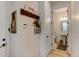 Hallway featuring coat rack with hooks, decor, thermostat, and an open door to bathroom at 8984 Eagle River St, Littleton, CO 80125