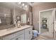 Bathroom featuring double vanity, sleek fixtures, and doorway to walk-in closet at 920 W 128Th Pl, Westminster, CO 80234