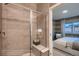 Bathroom featuring glass-enclosed shower with seating and a doorway view into bedroom at 920 W 128Th Pl, Westminster, CO 80234