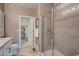 Bathroom showcasing glass-enclosed shower, neutral tiling, and shelving at 920 W 128Th Pl, Westminster, CO 80234