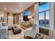 Cozy living room featuring a stylish cabinet, comfortable seating, and a large window with scenic views at 920 W 128Th Pl, Westminster, CO 80234