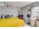Youth bedroom with bright yellow quilt and decorative desk area with chair and shelving at 1068 Milo Cir # A, Lafayette, CO 80026