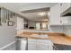 Open kitchen view showcasing sink, countertops, and a pass-through to the living room with fireplace at 1068 Milo Cir # A, Lafayette, CO 80026