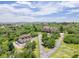 Expansive aerial view of an estate, showcasing lush landscaping, a guest house, and stunning mountain views at 1091 Colt Cir, Castle Rock, CO 80109