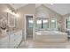 Bright bathroom with tiled floor, tub, and a vanity with a marble countertop at 1091 Colt Cir, Castle Rock, CO 80109