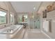 Bright bathroom featuring a soaking tub, large window with a view, and glass shower at 1091 Colt Cir, Castle Rock, CO 80109