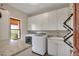 Laundry room with white cabinets, granite countertop, and modern washer and dryer at 1091 Colt Cir, Castle Rock, CO 80109