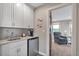 Wet bar area featuring white cabinetry, sink, mini fridge, and view of the living area at 1091 Colt Cir, Castle Rock, CO 80109