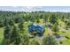 Aerial view of this two-story home in the mountains with shed and tree coverage at 5939 S Skyline Dr, Evergreen, CO 80439