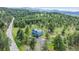High aerial view of this two-story home in the mountains with tree coverage at 5939 S Skyline Dr, Evergreen, CO 80439