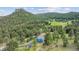 Wide aerial view of this two-story home surrounded by mountain trees at 5939 S Skyline Dr, Evergreen, CO 80439