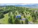 Wide aerial view of this two-story home in the mountains with shed and tree coverage at 5939 S Skyline Dr, Evergreen, CO 80439