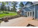 Home exterior featuring a wooden deck, stairs, well-maintained lawn and mature trees at 5939 S Skyline Dr, Evergreen, CO 80439