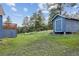 View of shed and the deck of this multi-story home with grassy backyard and tree coverage at 5939 S Skyline Dr, Evergreen, CO 80439