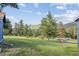 Backyard view from this home with grassy area and tree coverage at 5939 S Skyline Dr, Evergreen, CO 80439