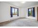 Bedroom featuring carpet floors and two windows with views of the surrounding forest at 5939 S Skyline Dr, Evergreen, CO 80439