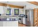 Well-appointed kitchen with white cabinets, stainless steel appliances, blue countertops, and bright natural light at 5939 S Skyline Dr, Evergreen, CO 80439