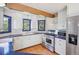 Well-appointed kitchen with white cabinets, stainless steel appliances, blue countertops, hardwood floors and a beam at 5939 S Skyline Dr, Evergreen, CO 80439