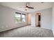 Spacious bedroom with large windows, ceiling fan, and gray carpet at 389 Smith Cir, Erie, CO 80516
