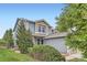 Charming two-story home with blue siding, green lawn and mature trees under a sunny blue sky at 389 Smith Cir, Erie, CO 80516