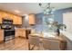 Well-lit kitchen with stainless steel appliances, wood cabinets, hardwood floors, and an eat-in dining area at 389 Smith Cir, Erie, CO 80516