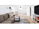 Open concept living room with a cozy sectional, neutral tones, and natural light at 4571 Beach Ct, Denver, CO 80211