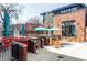 Outdoor patio area with red and wood seating, umbrellas, and a brick building with a sign at 4571 Beach Ct, Denver, CO 80211